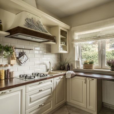 Elegant cooker hood in english styled kitchen, dark wooden frame, flowers painting.
