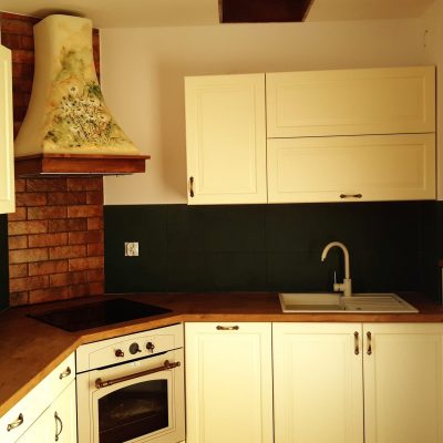 Wall mounted cooker hood with wooden frame and painting.