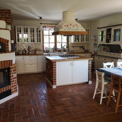 Bigger insular cooker hood with red flowers painting and wooden frame.